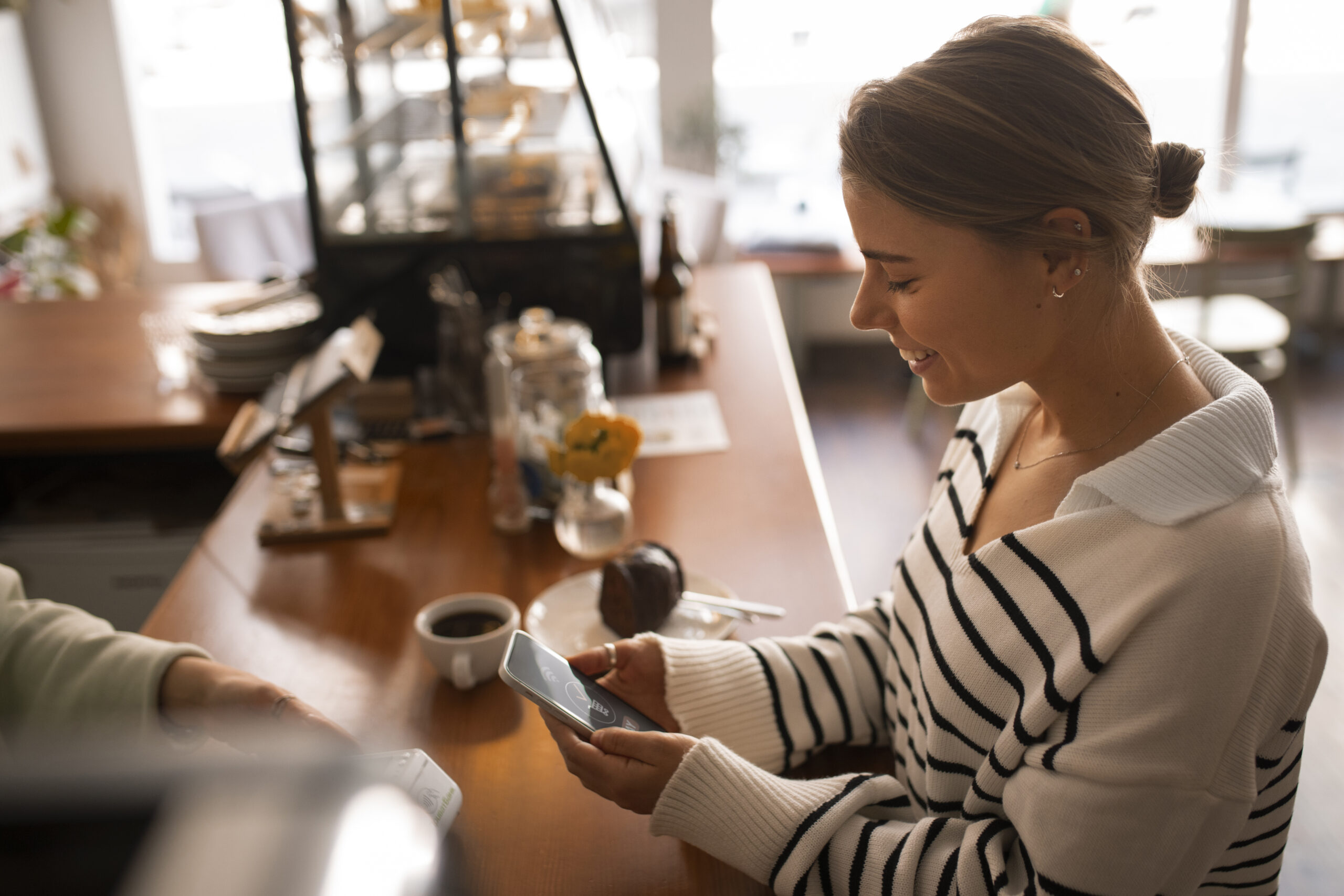 Customer using small business loyalty app in cafe